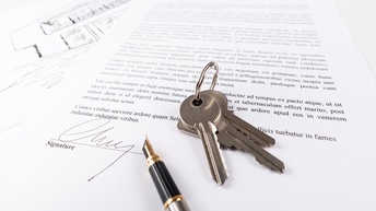 Unterschriebener Vertrag mit Schlüsselbund und Füllhalter