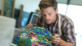 Person bemalt in Form von Glasmalerei ein Objekt