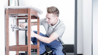 Ein Installateur bei der Montage eines Waschbeckens