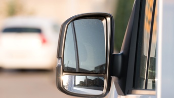 Detailaufnahme eines Außenspiegels von einem Transporter mit Bokeh