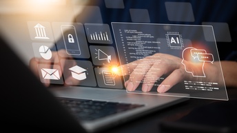 Nahaufnahme eines aufgeklappten Laptops mit grafischen Programmiericons.