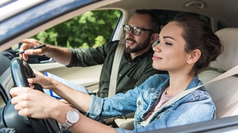 Zwei Personen angeschnallt und fahrend in Auto sitzend