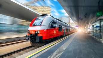 Ein rot-grauer Zug steht an einem Bahngleis