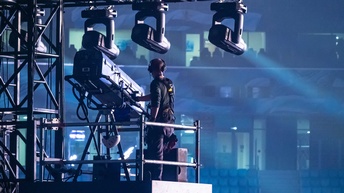 Ein Beleuchter bedient einen Scheinwerfer auf der Bühne