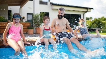 Vater und Kinder haben Spaß im Pool