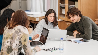 Junge Menschen sitzen um einen Tisch