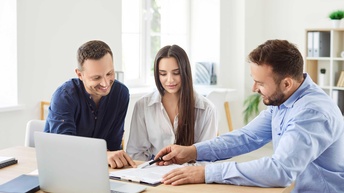 Ein Paar lässt sich von einer dritten Person etwas erklären