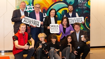 Gruppe mehrerer Personen, wovon einige Schilder mit Schriftzug Skills Week Austria in Händen halten