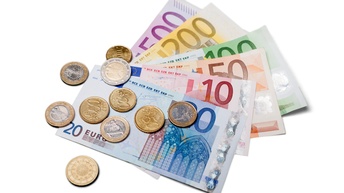 Detailansicht von 10-, 20-, 50-, 100-, 200- und 500-Euro-Geldscheinen in einem Fächer angeordnet, auf denen verschiedene Euromünzen liegen.