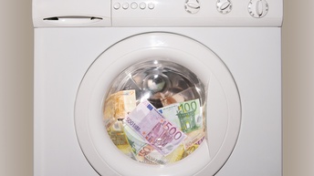 In einer Waschmaschinentrommel sind mehrere Euroscheine in unterschiedlichen Beträgen wie hundert, fünfzig, zweihundert oder fünfhundert.