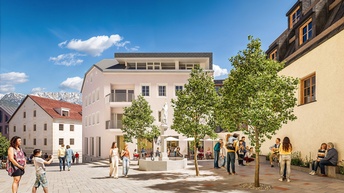 Belebter, neu gestalteter Platz im Decorona Quartier in Imst: Helle, modernisierte Gebäude mit klassischen Proportionen umrahmen einen offenen Platz mit Bäumen und zentralem Brunnen. Menschen flanieren, sitzen in der Gastronomie oder treffen sich im Schatten der Bäume. Im Hintergrund alpine Bergkulisse, im Vordergrund klare Pflasterstruktur und Aufenthaltszonen mit hoher Aufenthaltsqualität.