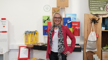 Person posiert vor einer Wand mit Geschenken 