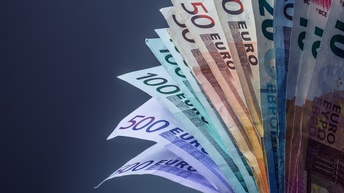 Detailansicht gefächerter Euro-Scheine vor grauem Hintergrund