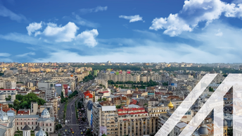 Stadtansicht von Bukarest mit historischen Häusern und Blick auf den  Universitätsplatz in Rumänien unter blauem Himmel.<br />
