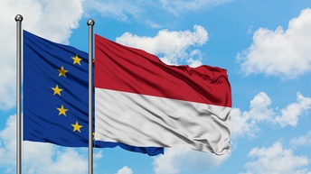 Die Flaggen der EU und Indoesiens vor blauem Himmel