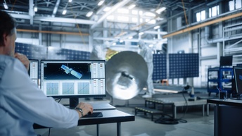 Ingenieure der Agentur für Luft- und Raumfahrt bei der Arbeit am Bau eines Satelliten. Sie entwickeln Raumfahrzeuge und berechnen die Flugbahn im Orbit am Computer