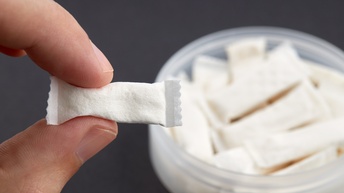 Hand hält Nikotinpouch zwischen zwei Fingern