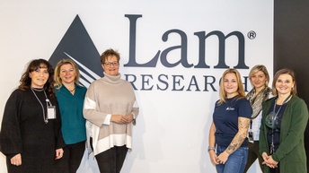 Eine Gruppe von Frauen vor einem Firmenlogo.