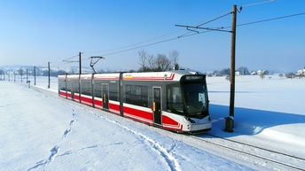 Zug fährt auf Schienen durch Schnee-Landschaft
