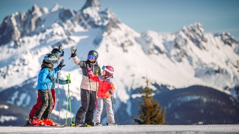 High Five von vier Personen in Skiausrüstungen