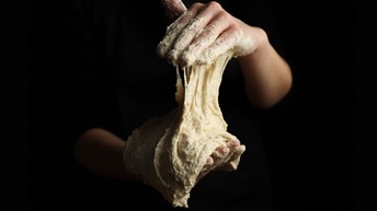 Hände, die Teig kneten