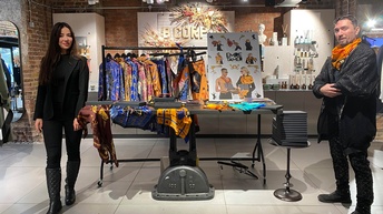 Frau und Mann stehen in Modegeschäft und schauen in die Kamera