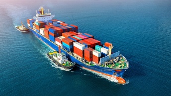 Beladenes Frachtschiff mit Containern wird auf offenem Meer von zwei weiteren Schiffen begleitet