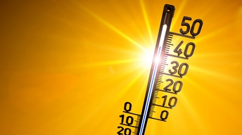 Im Vordergrund ist ein Thermometer vor einem orangen Hintergrund. Rechts sind die Zahlen bis 50 daran montiert. Die Anzeige des Thermometers ist etwa bei der Zahl 43
