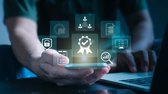 Eine Person hält ein Smartphone in der Hand, über dem Symbole für digitale Kommunikation im Kreis angeordnet sind