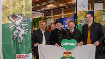 Vier Männer posieren neben einem Rollup und einem grünen Steiermark Herz bei den Steirerstundn