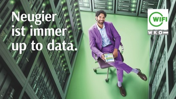 Topshot einer Person in violettem Anzug, die auf einem Stuhl sitzt mit Tablet in der Hand und lächelnd nach oben blickt in einem grünem Raum mit Serverracks. Darüber weißer Schriftzug Neugier ist immer up to data und das WIFI-Logo.