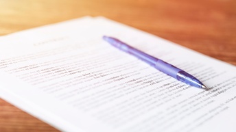 Ein Kugelschreiber auf einem bedruckten Blatt Papier