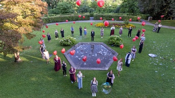Die Teilnehmer:innen beim Bundeslehrlingswettbewerb der Floristik haben sich in Herzform aufgestellt und halten einen roten Luftballon mit der Aufschrift Herzensangelegenheiten in der Hand.