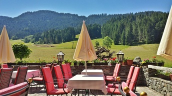 Blick auf die Terrasse eines Gasthauses in den Alpen mit