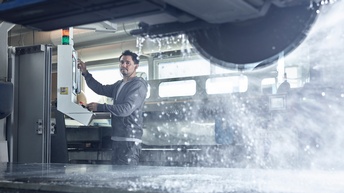 Ein junger Mann steuert eine Steinsäge