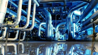 Industriezone mit Stahlrohren mit blauen Lichtreflexionen am Boden