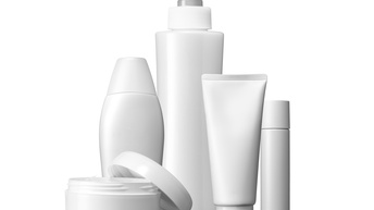 Auf und vor weißem Hintergrund stehen verschiedene komplett weiße Tuben, Dosen bzw. Verpackungsmaterialien für verschiedene Kosmetikartikel