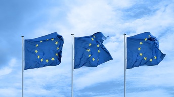 Drei EU-Flaggen flattern im Wind nebeneinander