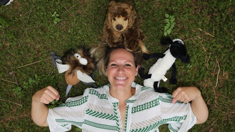 Eine lächelnde Frau mit Stofftieren.