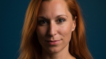 Eine lächelnde Frau mit roten Haaren.