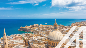 Blick von oben auf die Basilika Our Lady of Mount Carmel, in Valletta City, Malta. Blaues Meer und blauer Himmel im Hintergrund.
