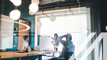 Geschäftsleute arbeiten mit Whiteboard und Dokumenten im Konferenzraum.