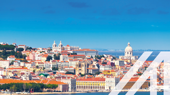 Panorama von Lissabon mit vielen historischen Gebäuden, Kirchen, weißen Häusern und roten Dächern unter blauem Himmel, am Wasser gelegen. 