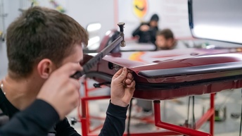 Dellentechniker beim ausbeulen einer PKW Tür