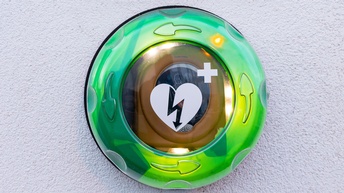 Ein an deiner Wand befestigter Kasten mit einem Defibrillator