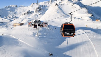 Gondelbahn vor schneebedeckter Berglandschaft im Skigebiet Gastein