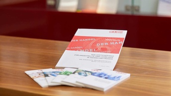 Diverse Broschüren zum Thema Kollektivvertrag sind auf einem Tisch aufgelegt