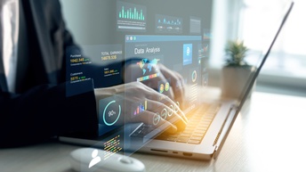 Nahaufnahme eines aufgeklappten Laptops mit grafischen Programmiericons.