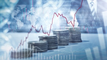 Collage von mehreren nebeneinander gestapelten Münzen, die im Verlauf an Höhe gewinnen, Overlay verschiedener Diagramme und der Weltkarte, im Hintergrund Person, die auf einen Peak deutet.