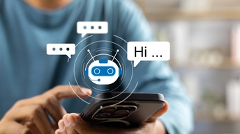 Nahaufnahme der linken Hand einer Person, die ein Smartphone hält. Über dem Smartphone ist die Grafik eines Roboterkopfes. Neben dem Kopf sind Sprechblasen. In einer Sprechblase steht Hi.